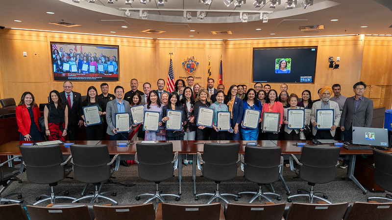 AANHPI community leaders and Councilmembers hold proclamations in the Council chamber for AANHPI Heritage Month.
