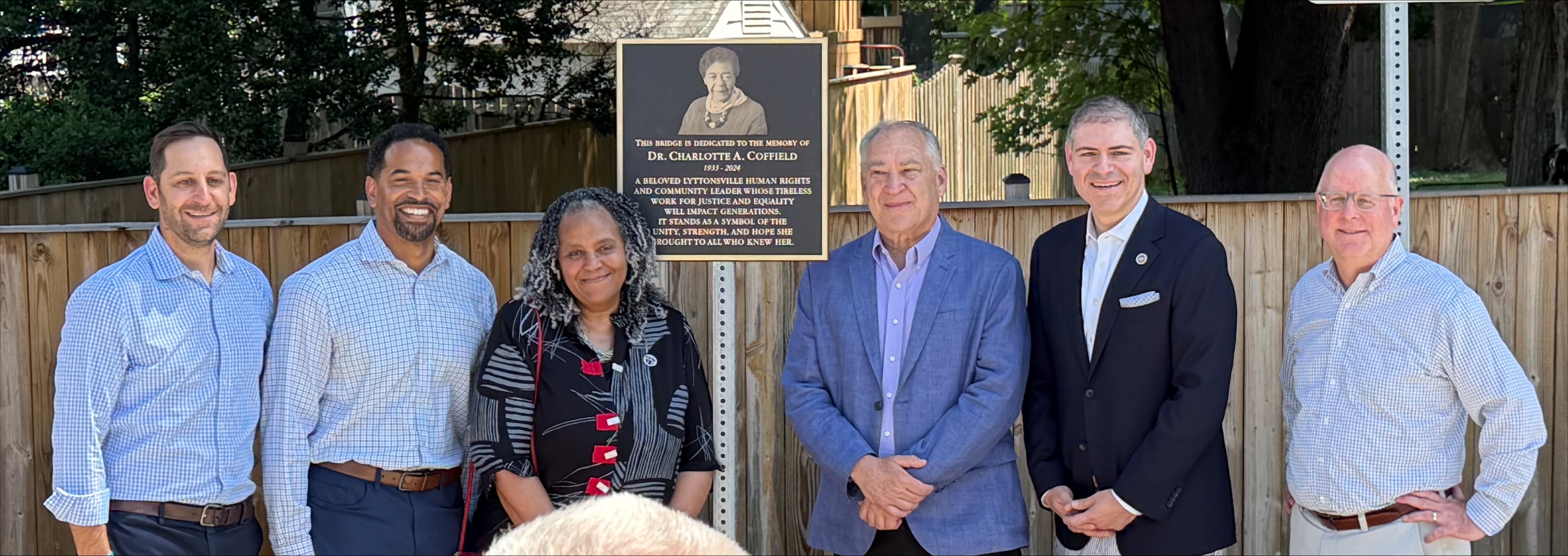 Elected officials and County Leaders stand with Myra Coffield to unveil plaque